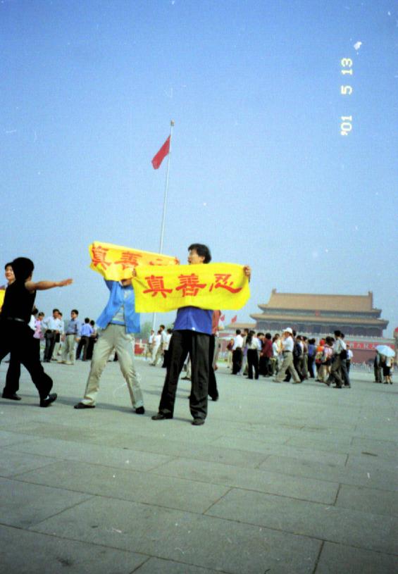 Китайці на площі Тяньаньмень тримають плакати із написом «істина-доброта-терпіння», вигукуючи «Чжень Шань Жень хао»
